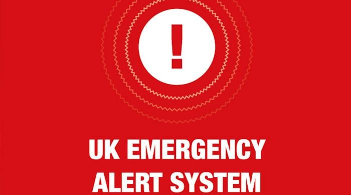 When will the trial of the first emergency alert system begin in the UK?