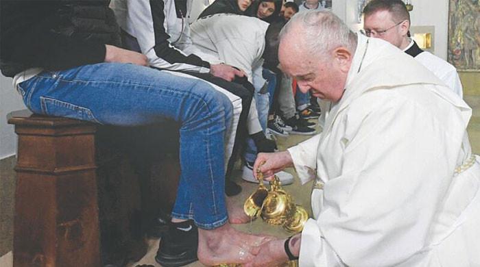 Why did Pope Francis wash the feet of teenage prisoners and kiss them?